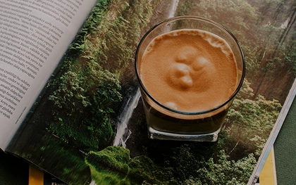 Um livro com uma xícara de café em cima, sugerindo um momento de leitura e relaxamento.